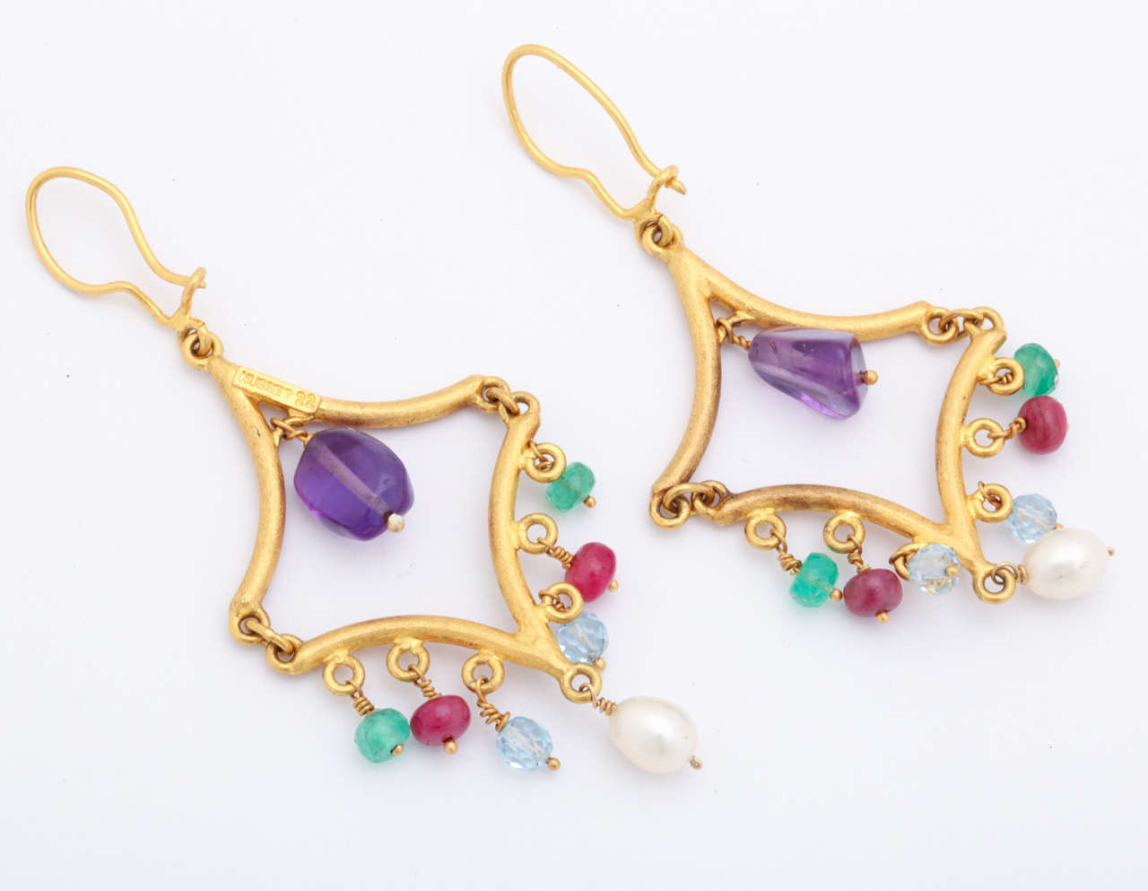 These show stopping earrings are made in 22 kt gold by Nusret in Turkey.The high carat gold gives these earrings an ancient look. The dangling stones are amethyst in the middle ,emerald, ruby, blue topaz and lastly pearl.
the generous ear wires are