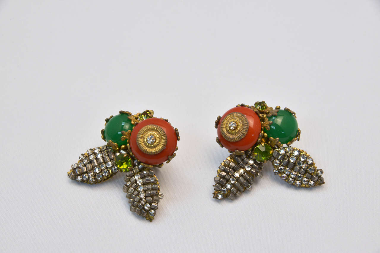 Extremely rare Miriam Haskell by Frank Hess brooch and earrings in seasonal Holiday tones, circa early 1950's. Ornate cluster work in both pieces. Emerald green glass beads set in elaborate guilt metal with a leaf shape and rose montees. Focal point