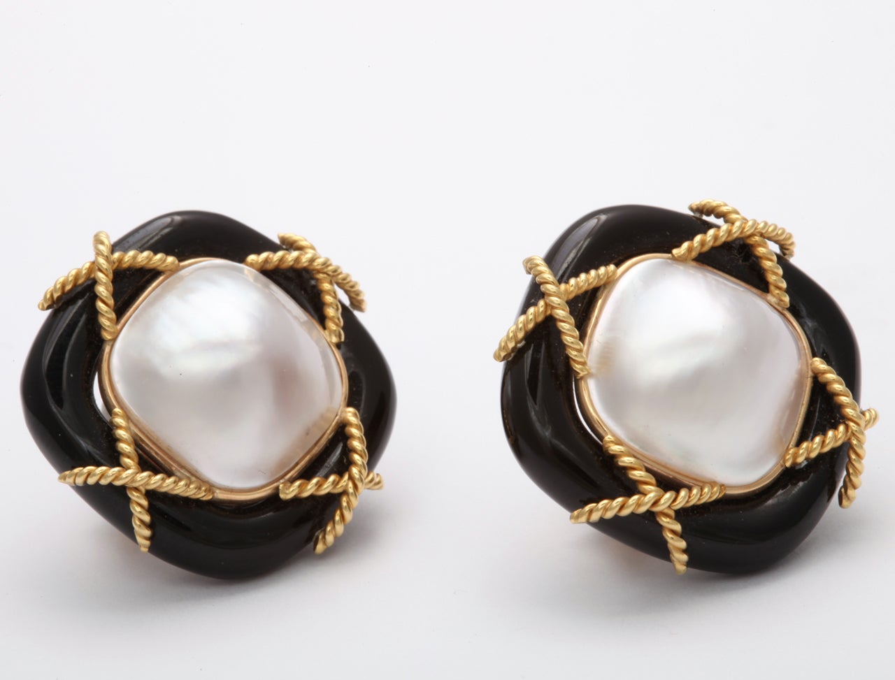 Clip on Earrings  -  Large Mabe Pearls - Cushion Shaped and 
bordered in carved Black onyx Frames accented by twisted Gold wire. Marked 14kt. Very tailored and elegant.