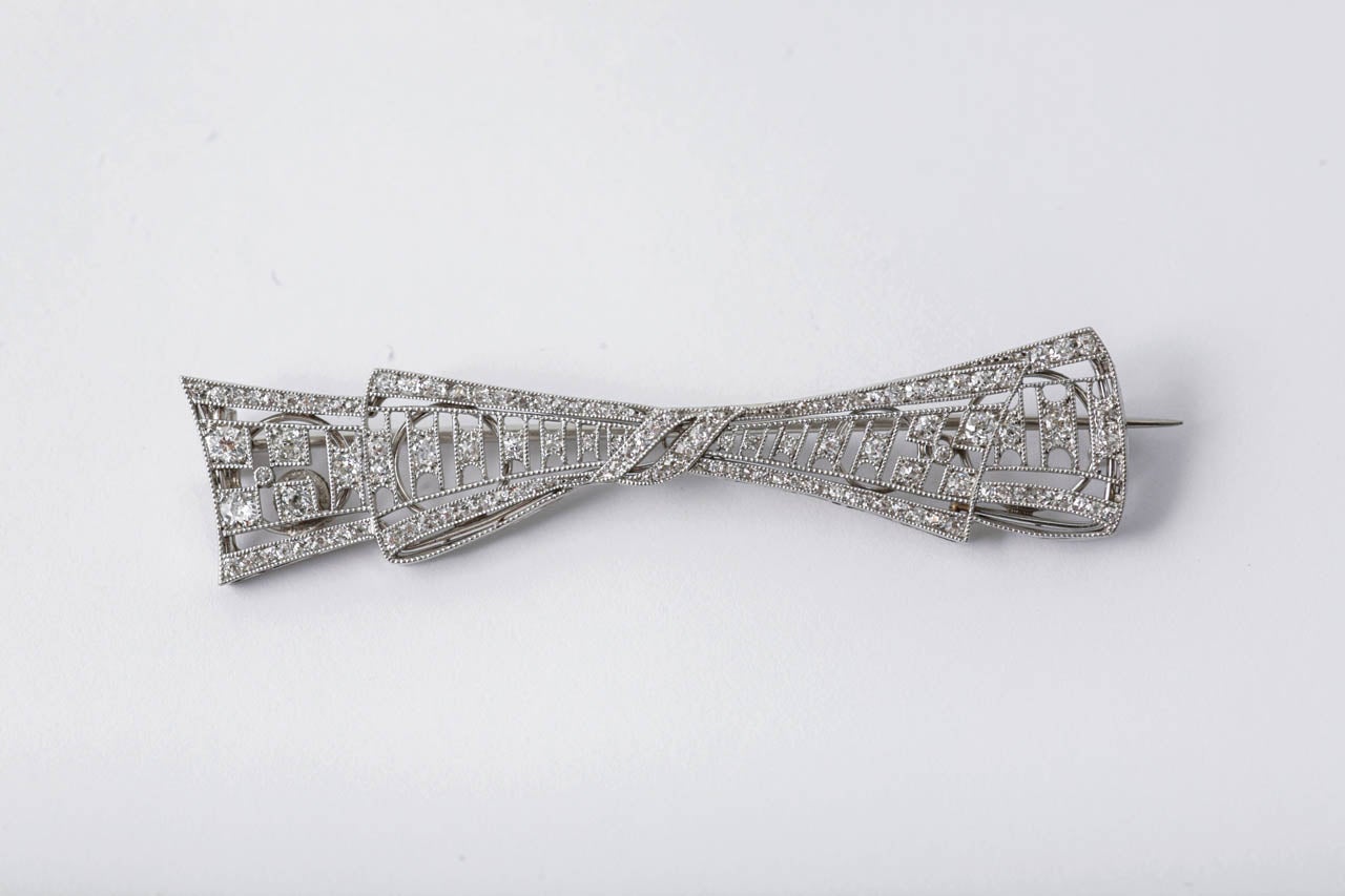 Diamond platinum mounted openwork set bow brooch, c1910.