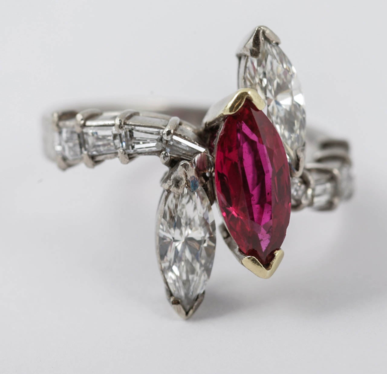 Marquise shaped ruby and diamond three stone ring with tapered baguette diamond shoulders, mounted in platinum.