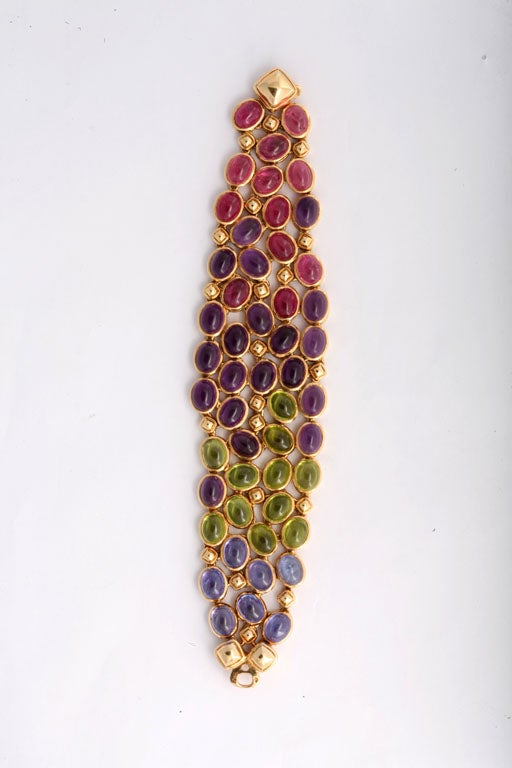 A stunning bracelet like this could only come from the jewelry house of Rene Boivin. It is so simple yet so utterly elegant. Cabochon sapphires, peridots, amethysts, and tourmalines are interspersed with geometric solid gold elements, and the