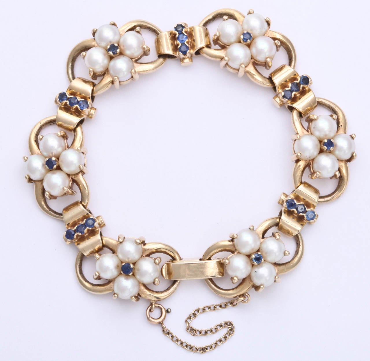 14kt yellow gold open link flexible bracelet embellished with 24 (4mm) cultured pearls and 21 Ceylon faceted beautiful color sapphires. Signed by Tiffany & Co. 