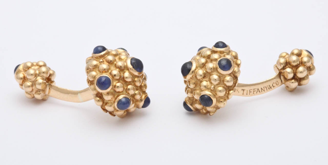 18kt yellow gold heavy cufflinks embellished with numerous cabochon beautiful color sapphires. Signed Tiffany & Co. 