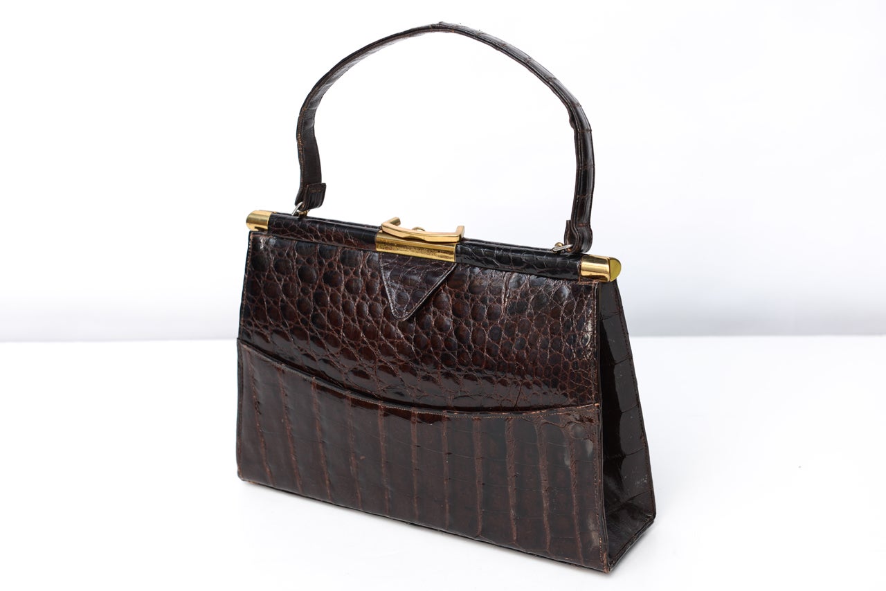 So classic yet versatile in design and material. You will always be in style. Large clutch type handbag of high quality construction. Easy to carry matching strap. Inside well detailed with four separate compartments, one zippered.