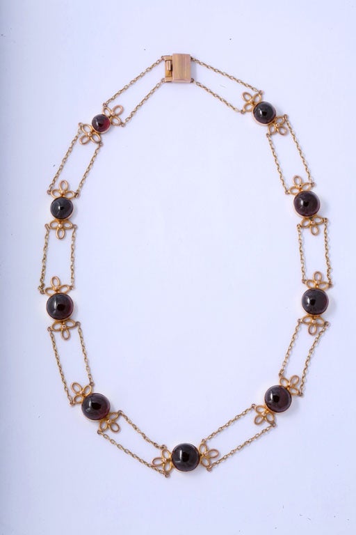 Handmade Necklace made up of 9 Cabochon Garnets set with florette ends and connected by chains.  The clasp is box shaped with a tab.