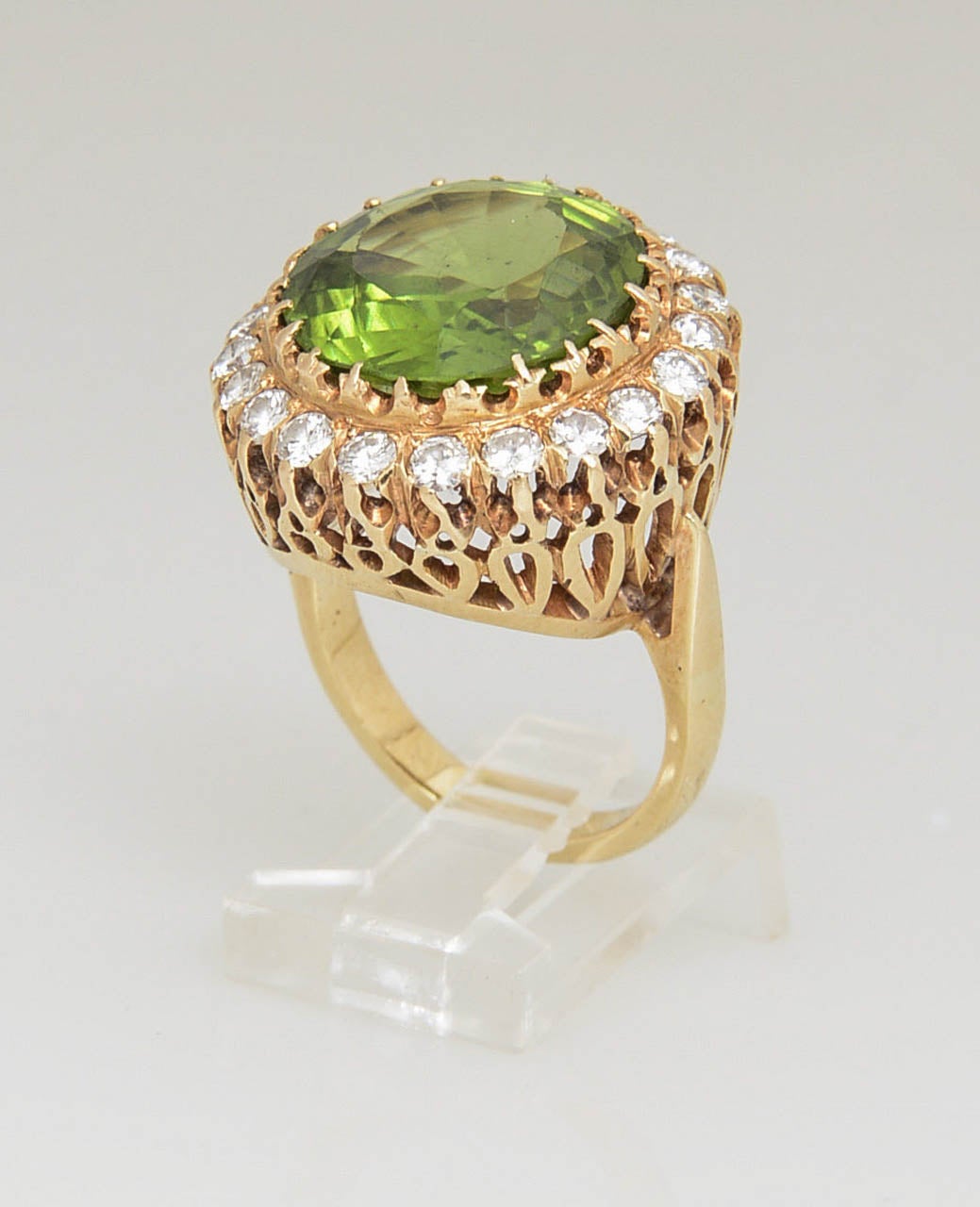 Rare large (15 carat plus) beautiful color peridot set in a diamond frame containing 22 diamonds approximately .03 carats each.  The stone is set in a beautifully designed open work 14k mounting.  
US size 8.5 - it can be sized.