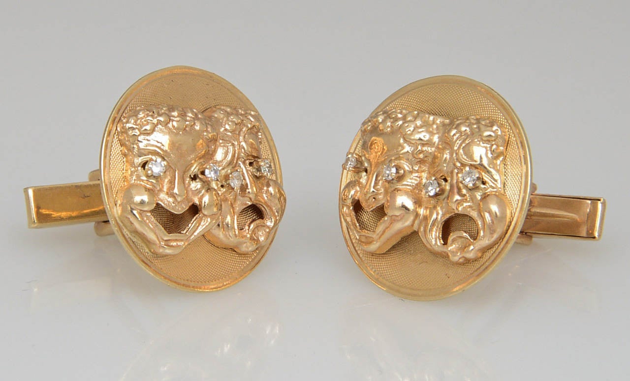 Raised comedy and tragedy faces with diamond eyes displayed on a florentine finish round disk.  These 14k yellow gold cufflinks have a t-back to go through the shirt.  Marked 14k M&M.