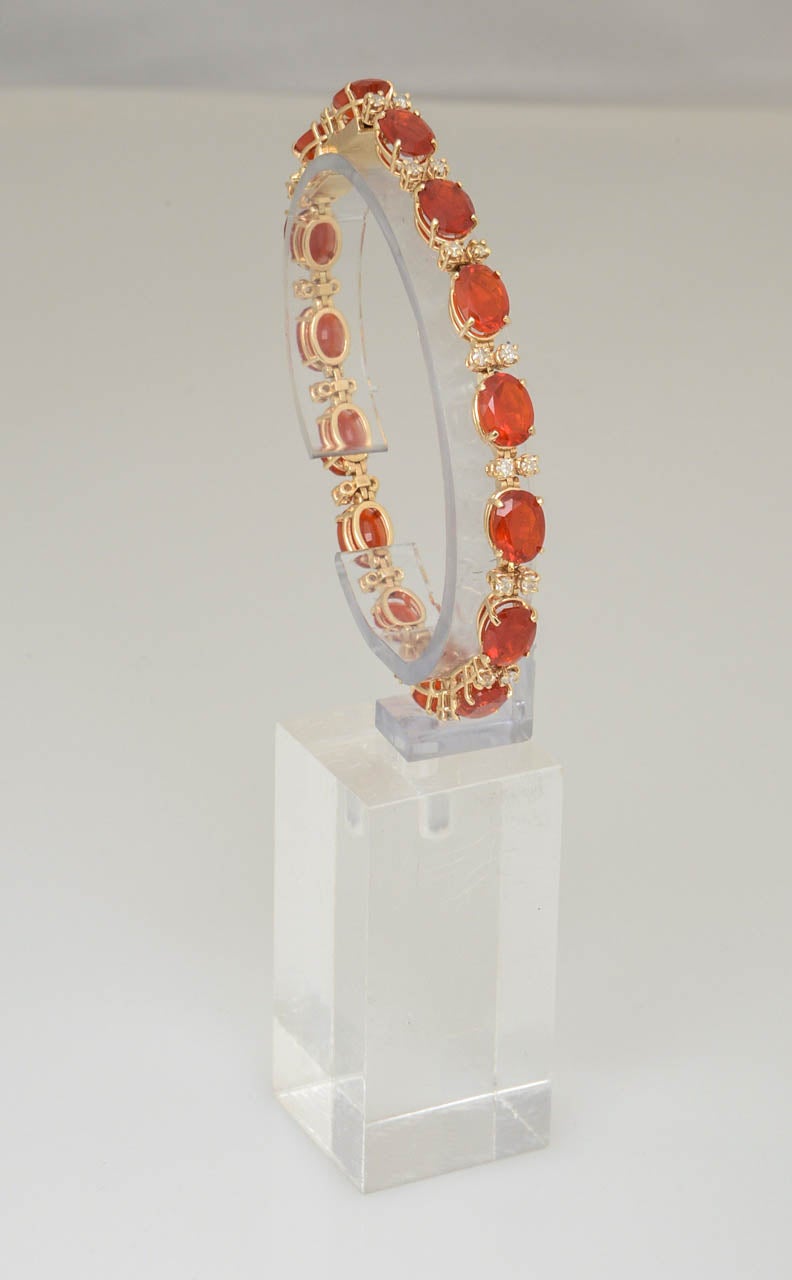 Very fine quality Mexican fire opal bracelet featuring 15 brilliant orange opals with 15 double diamond spacers.  This piece comes from an opal collector who only bought the best.  The mounting is 14k yellow gold and has a safety clasp.