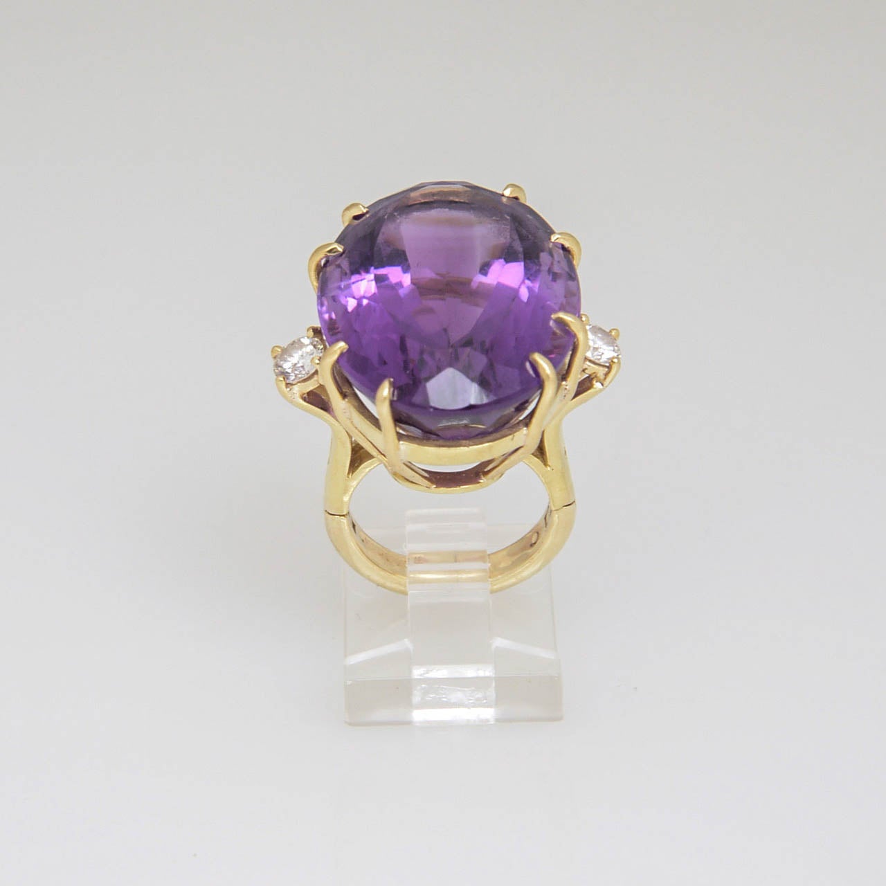 Large Oval Facetted Amethyst approximately 35c prong set with 2 - .25c each diamonds on either side mounted in a 14k yellow gold mounting.

US size 4 - It can be made larger.  

.5 depth is from top of stone to top of finger.