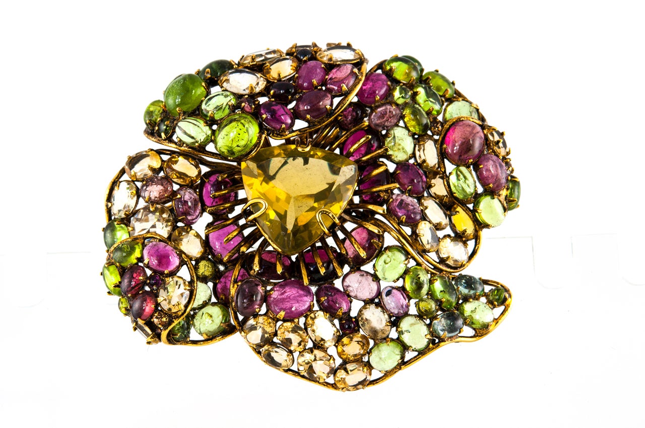 A phenomenal flower brooch by Iradj Moini with stones of amethyst, peridot and citrine set in brass. Signed on the back (see Image 6).