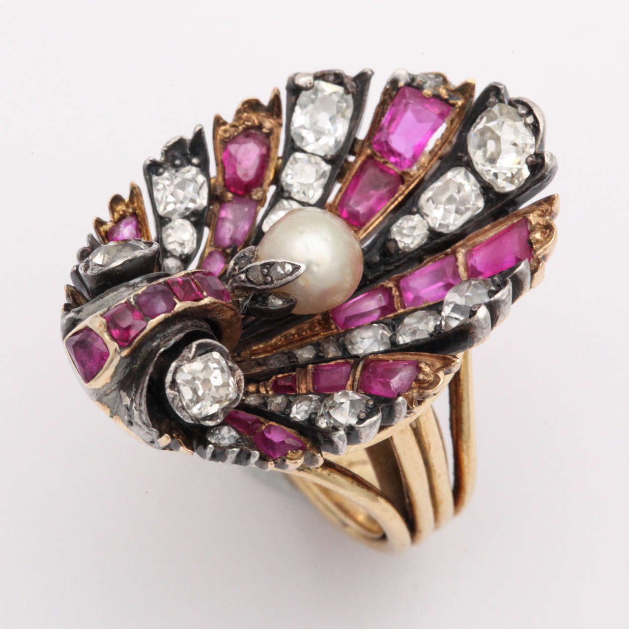 19th Century  Antique Brooch custom mounted - ca 1940 in Hand Made 18kt Yellow Gold Ring.

Brooch set in Silver & Gold with Old Mine Diamonds & Emerald cut Burmese Rubies in a shell Shape.  Centered with a Natural Pearl