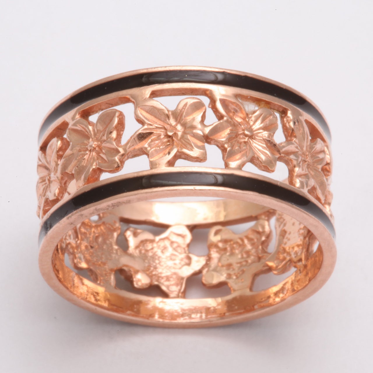 A band ring made in the United States in 14 Kt gold wraps ivy leaves around the finger. Ivy clings and intertwines in endless attachment which makes this a meaningful ring for lovers. The borders are emboldened with black enamel giving definition to
