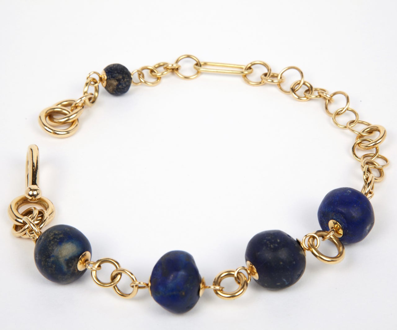 Necklace with various sizes of 18K gold links, with original slide-in clasp, centering four large lapis lazuli beads dating from the 2nd millennium B.C. & a smaller matching bead. 
Necklace length is 15.7 inches, largest bead is 0.8 inch in