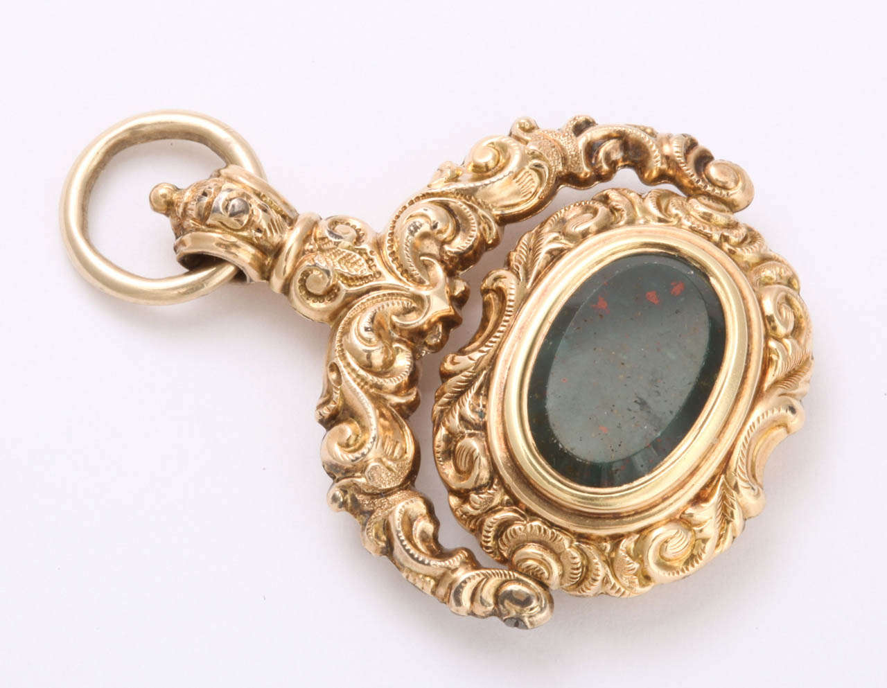 The bloodstone spinning section of this gold engraved fob is sprinkled with  red spots and is bevelled creating a higher center. This fob is handsome. Outstanding is more accurate  as the repousee engraving on the gold and the proportion of the