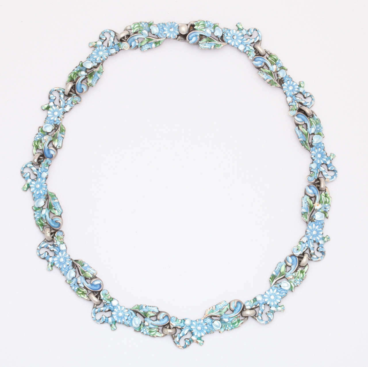 The lustrous enamel of Margot has immediate impact when you see this necklace. The pastel blue and white glows as if pearls were imbedded in the color. The necklace speaks color rather than silver. It can be well enjoyed by day or evening and though