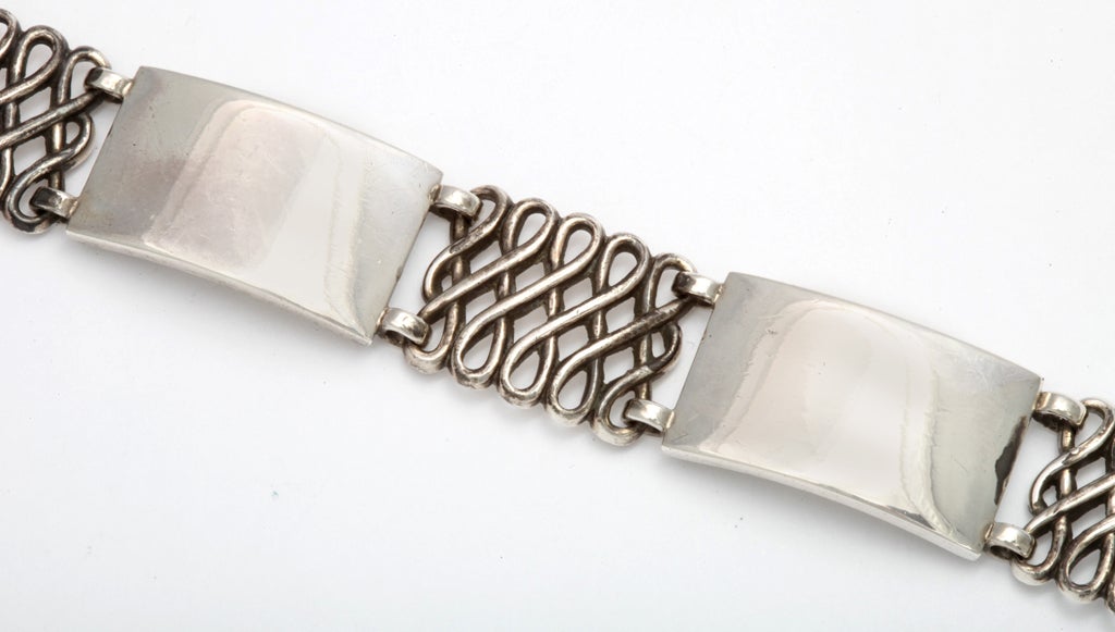 An older design Georg Jensen bracelet made by the master in 1939. Both men or women will wear it alone or with other silver and gold bracelets, The links alternate, one open braided link with one solid rectangular links for intriguing texture. The