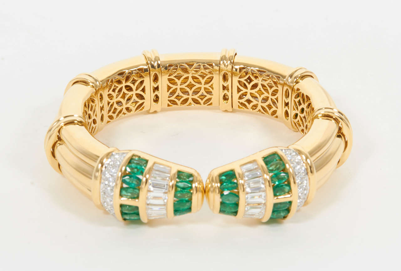 What an amazing piece!

The cuff opens slightly with a spring motion. 

7.10 carats of fine marquise cut green emeralds.

7.70 carats of white round brilliant cut diamonds.

18k yellow gold.