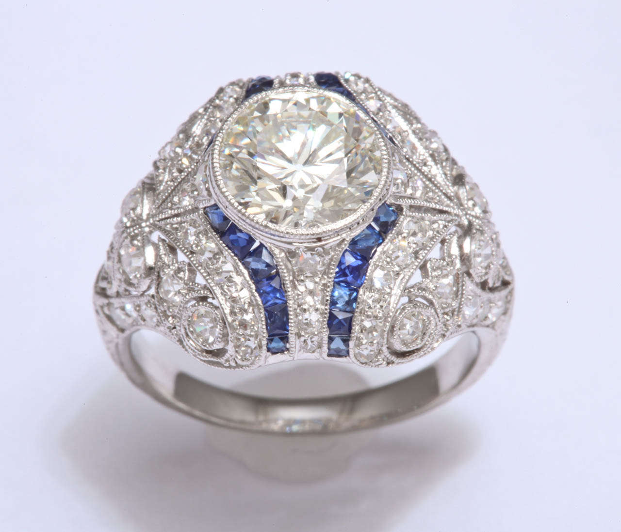 Gorgeous Art Deco ring featuring one round brilliant weighing 1.72 carats flanked with calibre sapphires and diamonds. 
Wonderful condition!!!