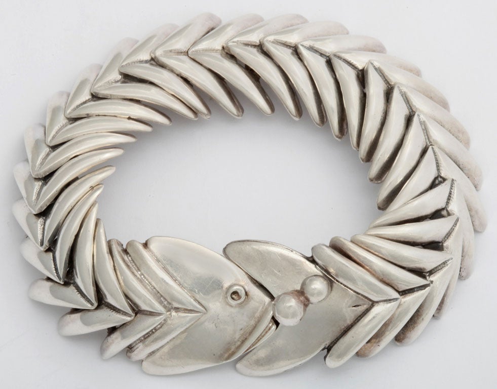 Hallmarked sterling silver bracelet by D'Molina. This fish motif bracelet is exceptionally comfortable because it is composed of 26 articulated and hinged pieces. Fitted with a tongue-in-box clasp which connects the fish's head to it's tail. The