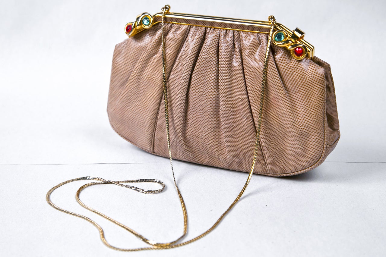 skin clutch with optional chain for shoulder purse use. featuring jeweled clasp. circa 1970's.