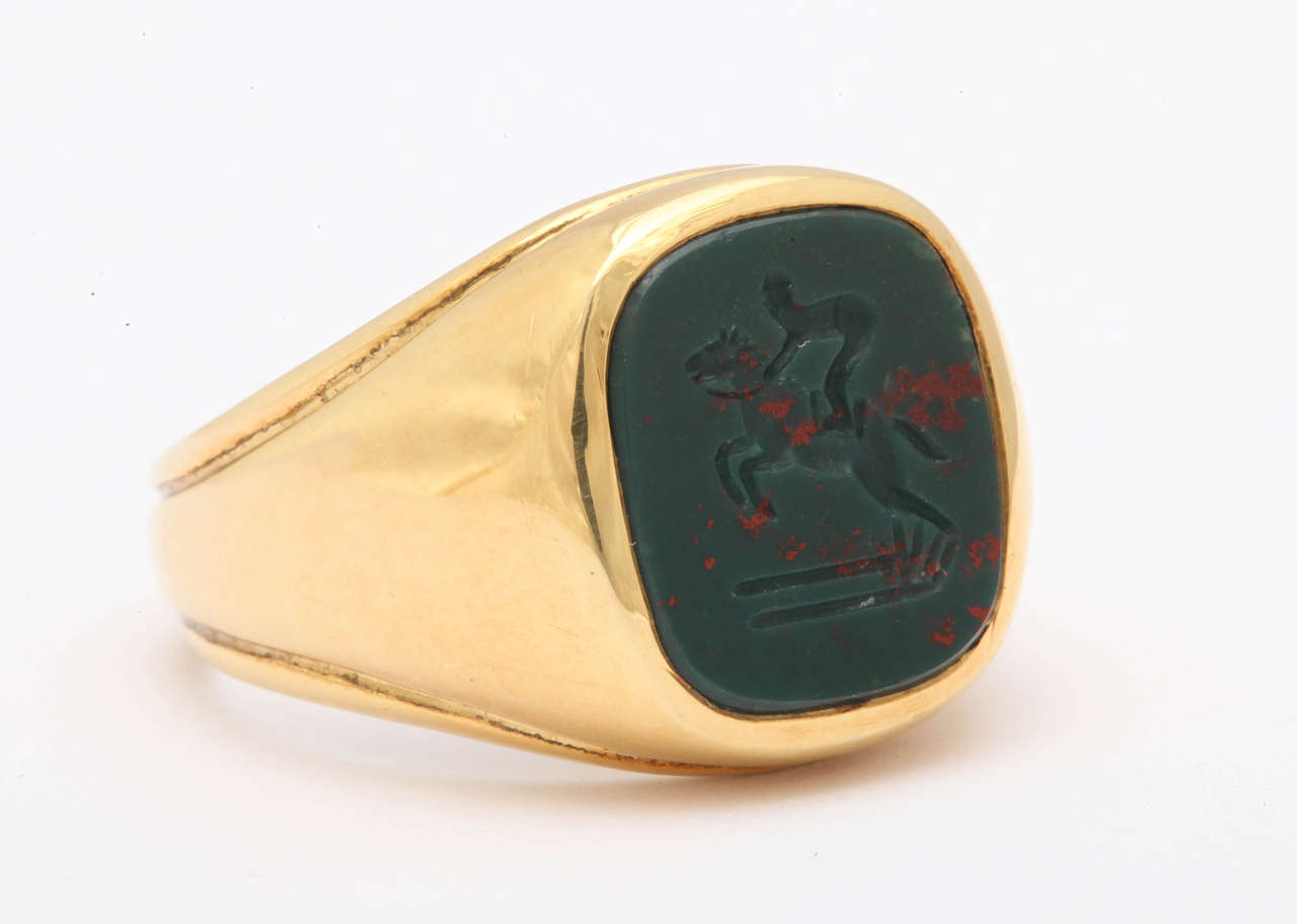 The intaglio was carved in Idar-Oberstein, Germany from Scottish bloodstone. It depicts a horse and rider jumping over a fence. This is a great ring for the steeple chaser or fox hunter or any equestrian sport enthusiast. The ring is now a size 9.5