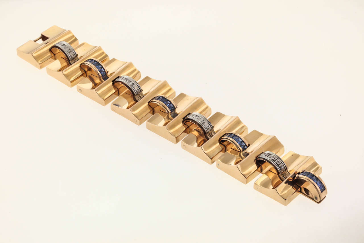 18K yellow gold Retro-Modern link bracelet, circa 1940's, alternates diamond-set and French-cut sapphire-set arched links with high polished concave wave links. The bracelet is 1-1/8