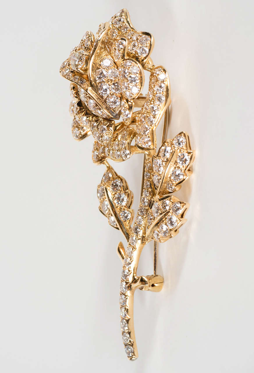 This is an eye-catching design depicting a rose and stem that  is seemingly covered with a heavy dew of  158 full cut shimmering diamonds weighing approximately 2.5  carats  , all the diamonds are approximately VS clarity, mounted in 18 karat yellow