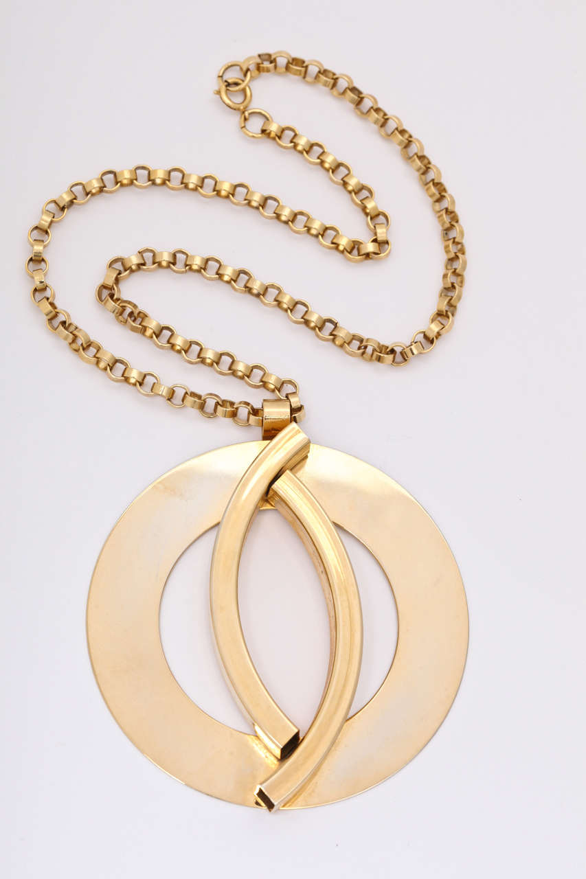 Large flat circle medallion necklace with two raised arch pieces on a chunky chain. Chain is 20