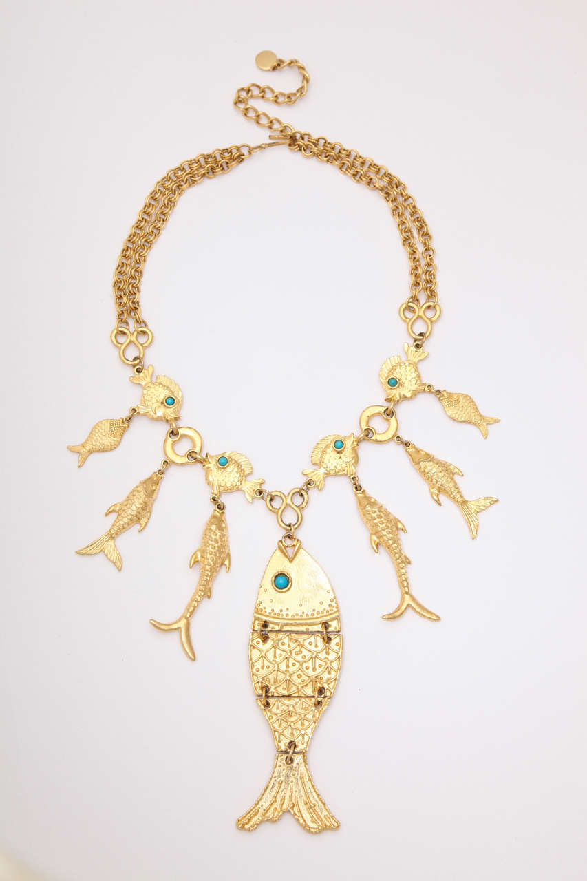 Goldtone green eyed fish necklace with one large fish and 10 additional fish. Large fish is 4.25