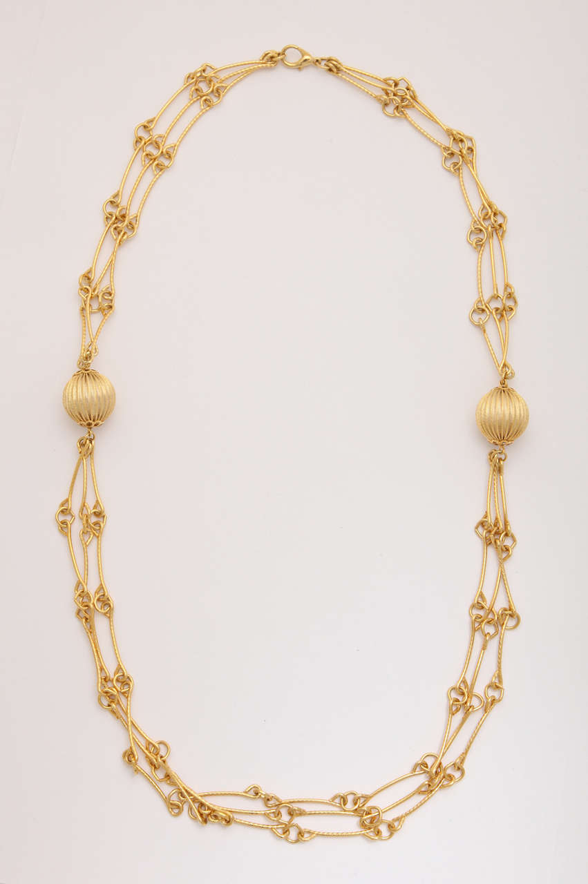 Triple strand link necklace with two balls.