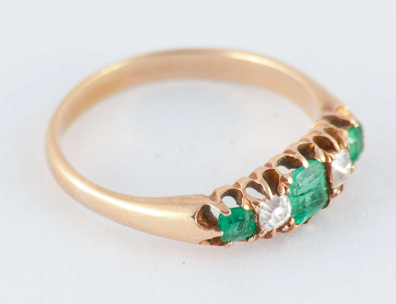 Edwardian five stone ring of three emeralds and 2 diamonds set in 15K gold. Wonderful to wear alone or stack with other rings. This ring is a size 7 1/4.