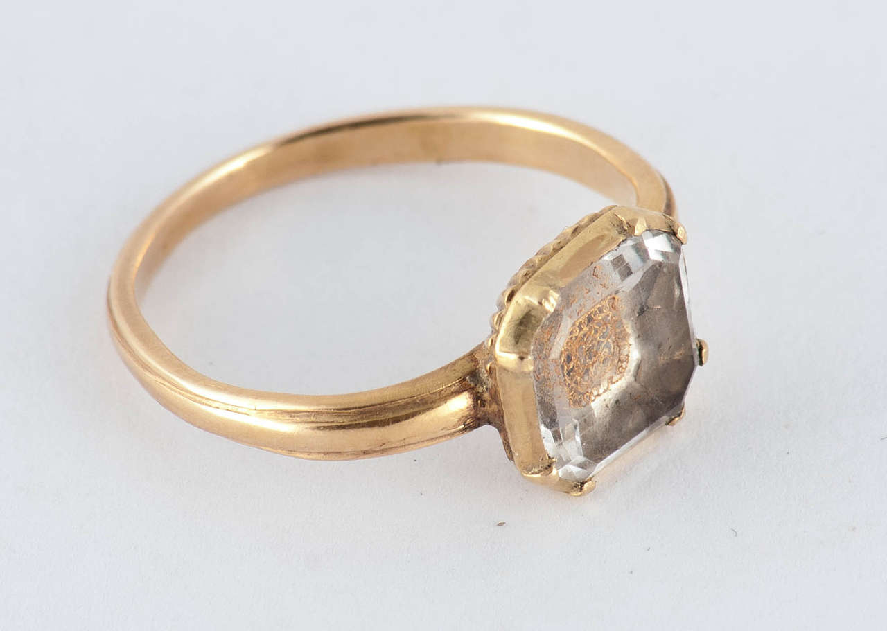 Seventeenth century Stuart carved rock crystal ring set in 18K gold. The crystal is mounted over woven hair that displays a gold wire cipher. These rings became popular after the death of King Charles I in 1649. The ring is a size 7 3/4 and measures