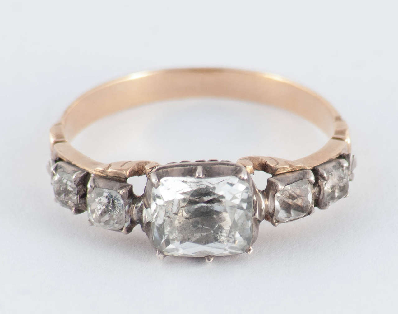 Lovely Georgian five stone paste ring set in 15K gold and silver. The center stone is set in an ornate basket setting. This rare ring is great to wear alone or stacked with other rings. The ring is a size 9.