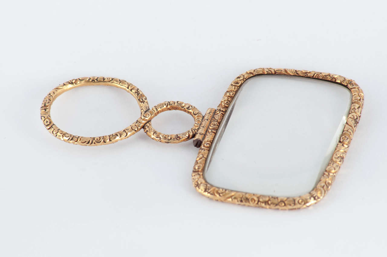 Large Georgian quizzing glass or magnifier in 18K cased gold with floral chasing.
Both men and women wore quizzers on long chains, the ladies tucking them into their wide sashes. At social affairs they were often used to look over and make comments