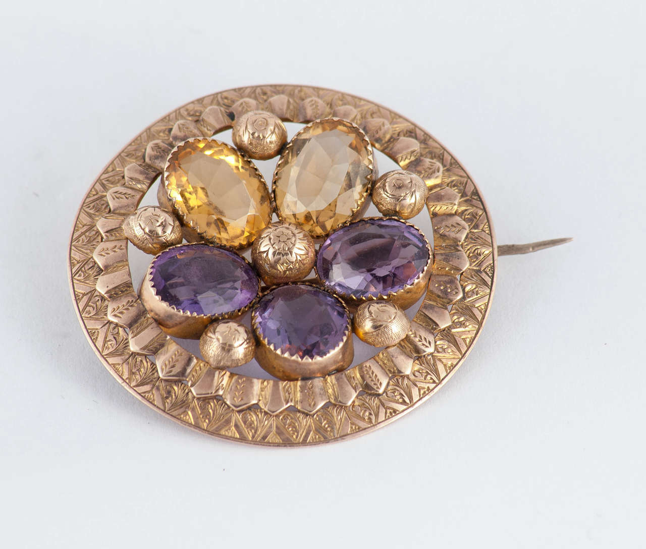 Lovely Victorian pansy pin set with amethysts and citrines in an engraved halo of 9K gold. The pansy was a popular design in Victorian jewelry as the sound of the word was similar to the French 