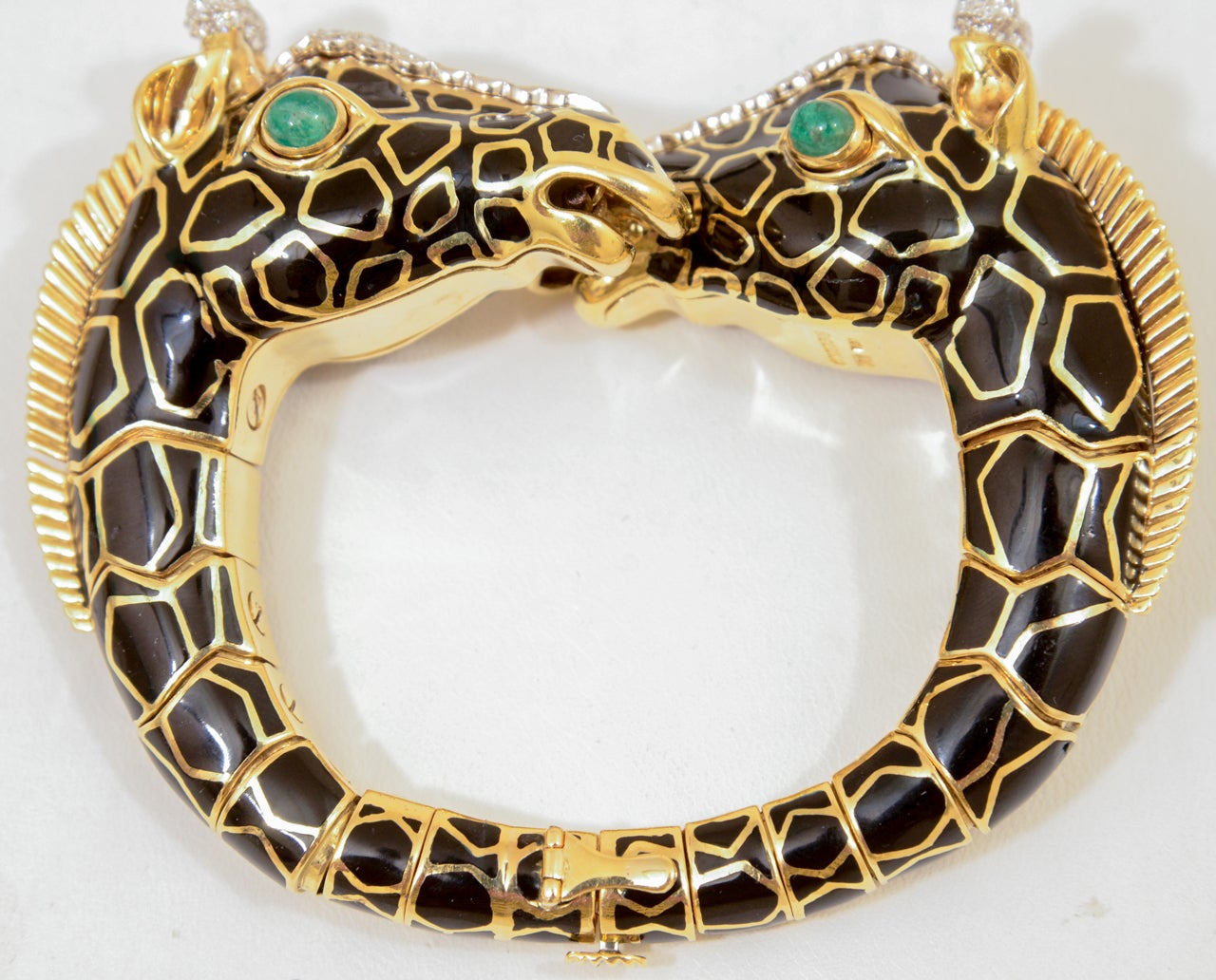 David Webb Giraffe Bracelet. Approximately 2.40 cts, Black Enamel accented in Platinum and 18k gold.

Enhanced emerald cabochons measuring 5.00 x 4.00 mm

Gross weight 132.92 grams