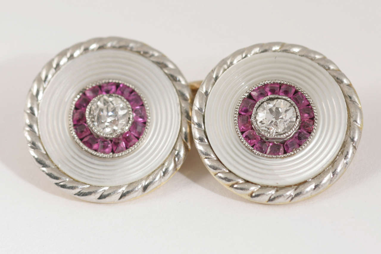 A pair of antique cufflinks in 18 carat yellow gold with a white gold border. Double sided with a central old cut brilliant diamond surrounded by shaped Burma rubies, on a mother of pearl background. Two smaller matching studs to complete the