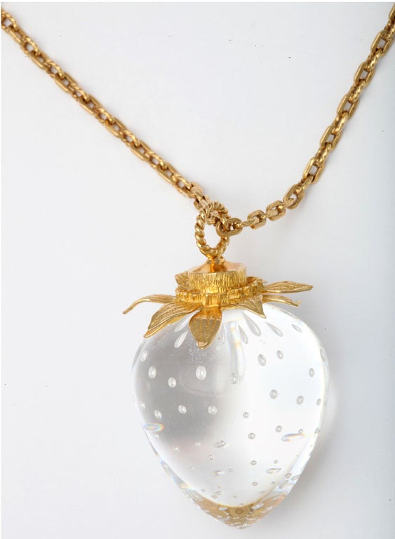 Steuben crystal Strawberry with internal bubbles and mounted with 18kt Yellow Gold multi-leaf top. Signed S & 18kt.  Hanging from 18kt associated gold chain weighing 8.8 dwts and measuring 25
