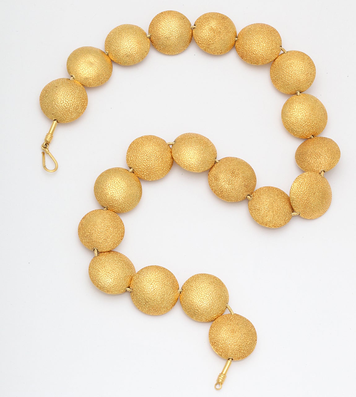 A necklace composed of twenty 18kt yellow gold lozenge beads strung onto an 18kt yellow gold snake necklace.