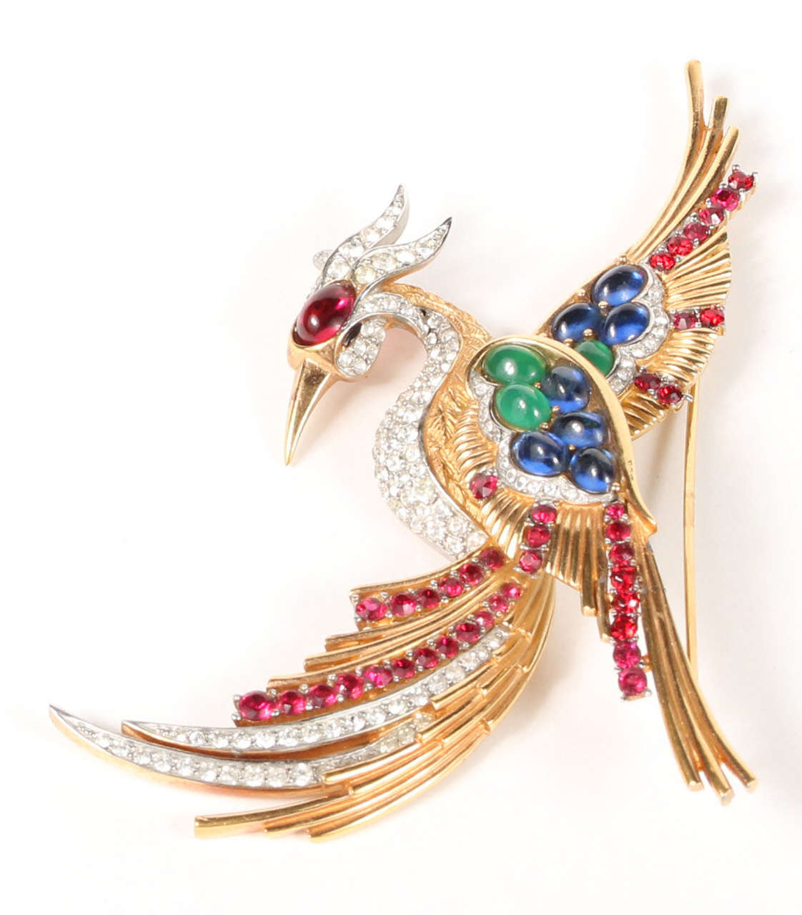 A stunning piece of vintage costume jewelry by Boucher, this gilt metal phoenix pin has been set with emerald, ruby and sapphire glass cabochons and ruby and clear rhinestones. Marked on the back 