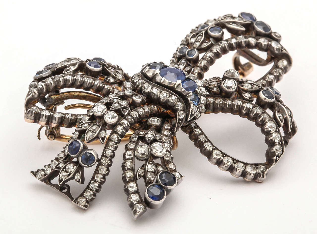 The exquisite silver on gold bow is set with single-cut diamonds and circular sapphires