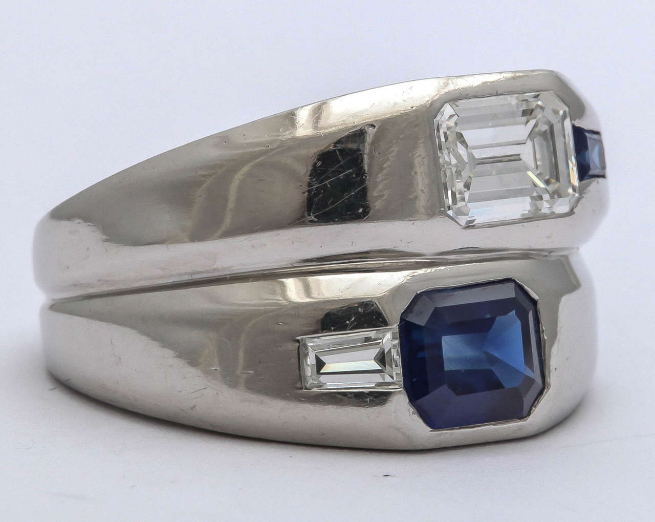 Fabulous double wide Platinum band with asymmetric opposition of an approximately 1.10ct Emerald cut Diamond and a Sapphire Baguette  and an approximately 1.30ct Emerald cut Blue Sapphire with a 15pt Diamond Baguette.  Perfect for a man or as a