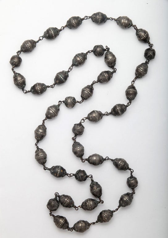 A sterling silver and diamond necklace composed of round sterling silver beads which have been set with diamond flower caps and sterling silver pellet beads which have been set with diamond flower caps and diamonds around the belly.