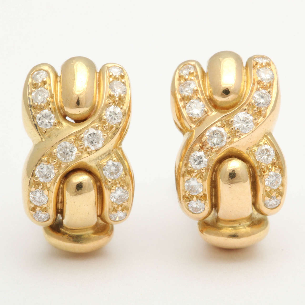 A pair of scintillating 18k gold earrings, each in the form of an X or 
