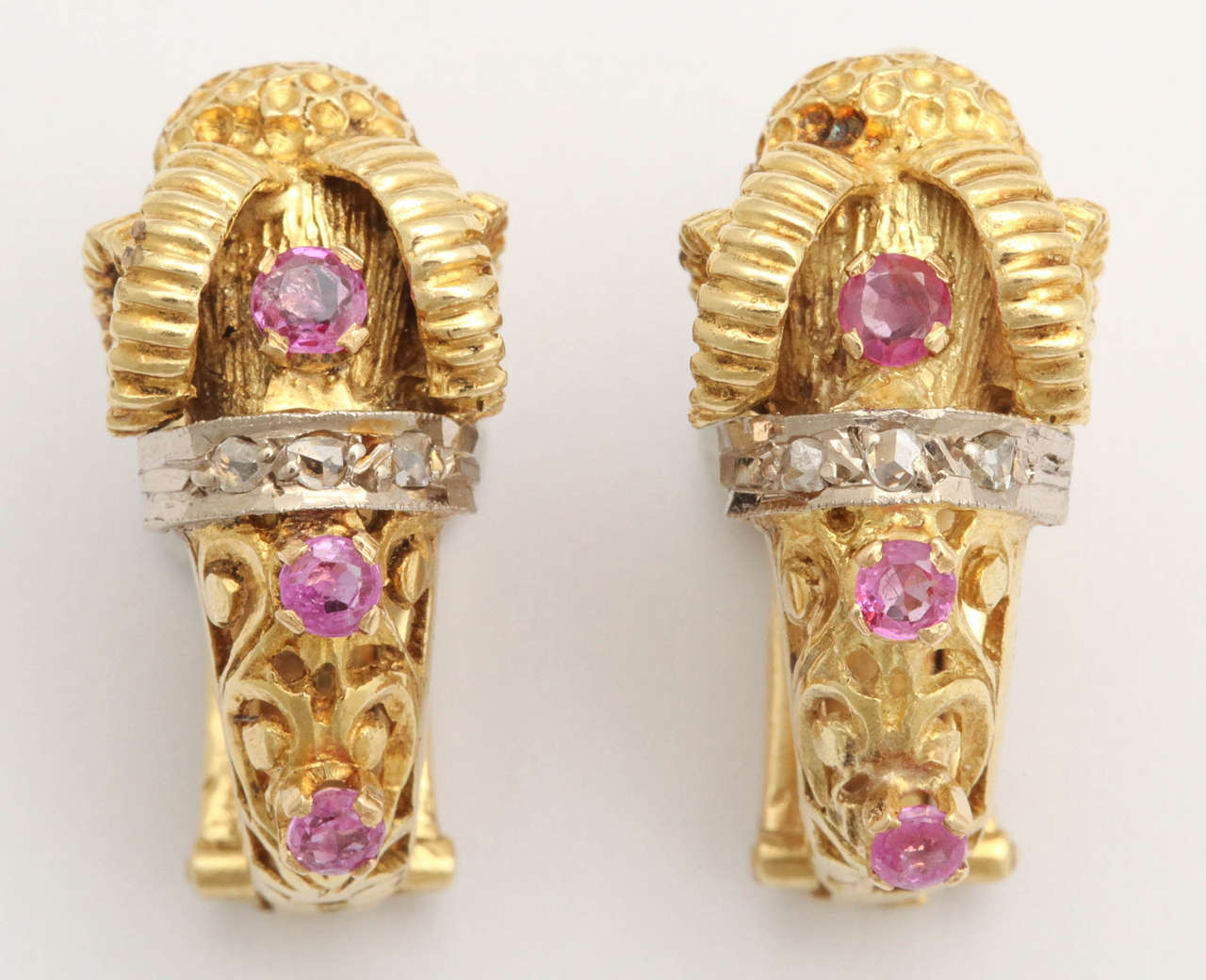 A pair of substantial Greek 18k gold ear clips each designed as an openwork 18k gold ram's head, an ancient symbol of prominence and power, set with rubies and diamonds.

With French control marks.

1 in. (2.5 cm.) long.