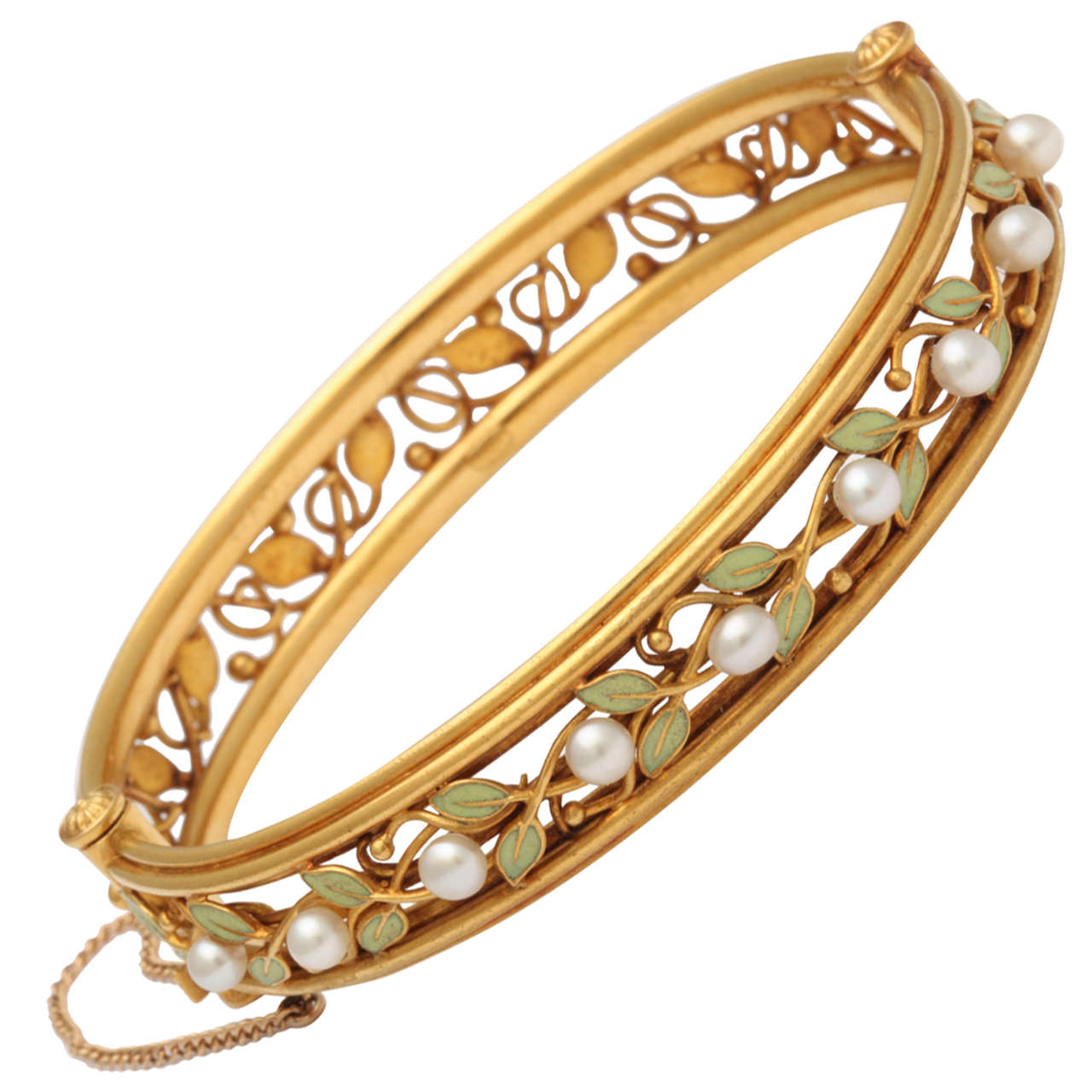 Rare Arts & Crafts bangle bracelet designed as an openwork vine of 18k gold and green enameled leaves, the upper half enhanced with freshwater pearls. The gold bracelet opens on a hinge and is fitted with a plunger clasp. A masterpiece of American