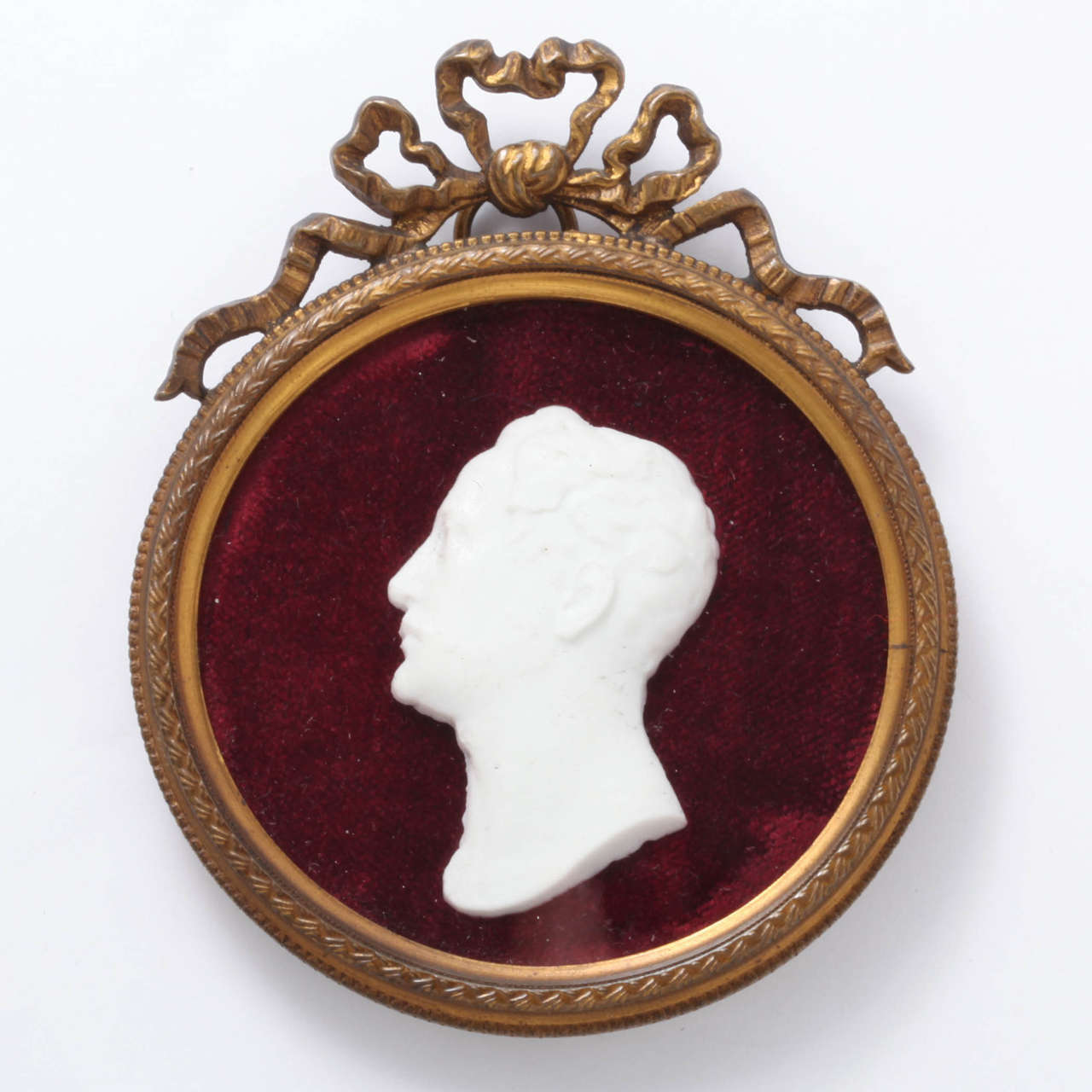 Depicting the Russian emperor, Tsar Nicholas I (r 1825-55) in profile within a 19th century neoclassical style bronze circular frame.

French, 1825-55.

3 3/8 in. (8.5 cm.) long including bow.