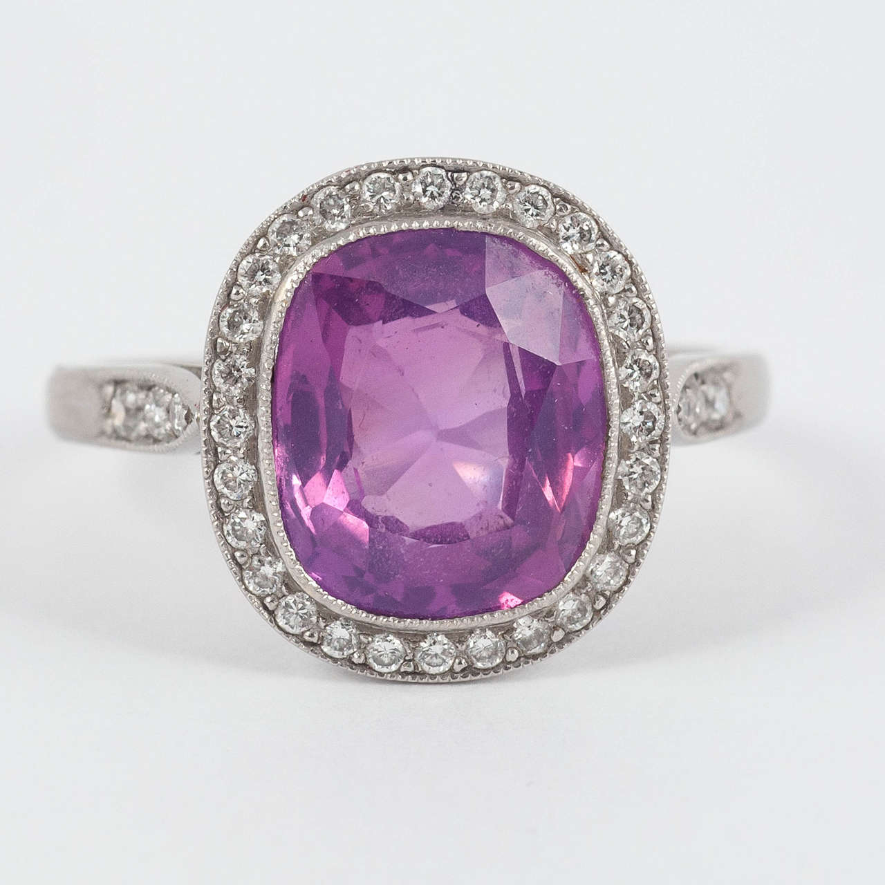 Fine natural pink cushion shaped Sapphire of Ceylon origin surrounded by Diamonds and set in Platinum

Finger size M 1/2