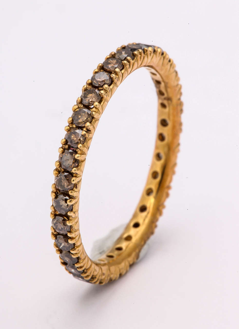 This is a very interesting eternity band featuring beautiful brown diamonds. The ring is 18 kt yellow gold, size 8 3/4, and has 1.16 cts. of diamonds. This ring can be made in any size. It can be worn by itself or complimenting other rings in your